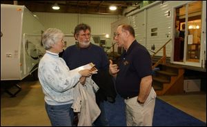At the show, Kris and Bob Stoner discuss with Bill Kast of Rainbow RV some of the different vehicles that his company has up on display.