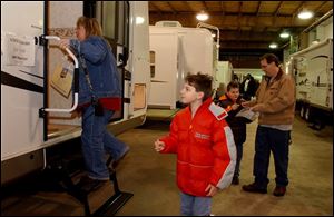 Amy Haas of West Toledo, along with sons Corbin, 10, and Tanner, 9, and her husband, Terry Haas, check out a recreational vehicle at the Lucas County RV Show at the Lucas County Recreation Center. 