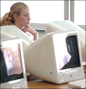 Lauren Baker, a junior at Tiffin Columbian High School, reads an assignment for the Advanced Placement biology course she is taking online through Virtual High School, a Massachusetts-based consortium. 