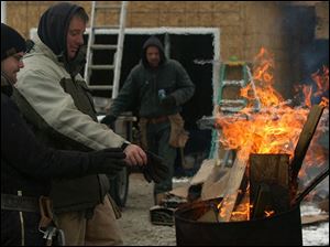 ROV hand warmer From left: construction workers Josh Guilda and Chuck Comer warm their hands and gloves with a barrel fire during a break from the cold while building a house on Hill Ave. in Toledo Friday, Feb. 11, 2005. They are from C. Comer Construction. Chuck is the owner. The Blade/Lori King
