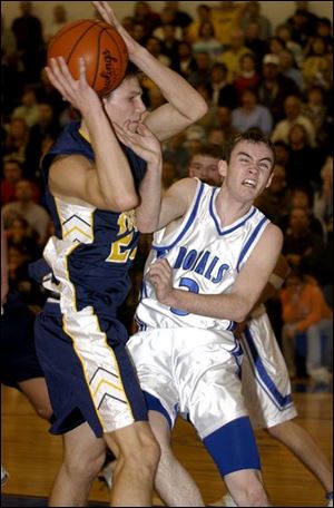 Woodmore's Tyler Rosenberger holds onto the ball despite heavy defensive pressure from Elmwood's Brian Barndt.