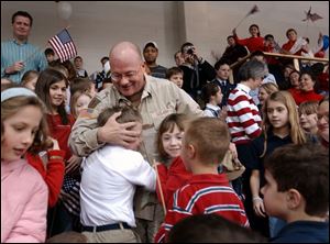 Sgt. Jeff Gagle, elementary principal at Toledo Christian School, is greeted by his students during a welcome-home ceremony.
