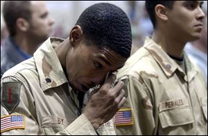 Spec. Joshua Bey of the 216th Engineer Battalion wipes away tears while  Amazing Grace  is played in honor of three fallen comrades. The soldiers were welcomed home yesterday.
