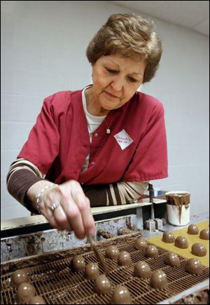Billie Smith puts the finishing touches on chocolates at Dietsch Brothers.
