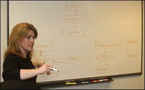 Dr. Mary Kay Smith draws a flow chart in her Medical College of Ohio office explaining traditional African belief systems. Her collaborations with Zambians have helped to develop anti-AIDS programs that fit the culture.