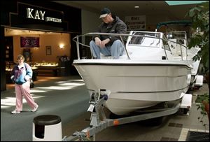 Sam McFarland of Genoa scrutinizes a boat up close during Woodville Mall's boat show, which ends Feb. 27.