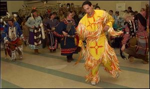 Juan Reiter of Cincinnati dances in an Apache outfit that honors his family's ancestors. 