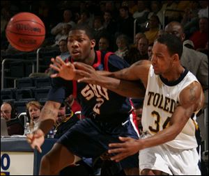 Toledo's Keith Triplett and Southern Methodist's Devon Pearson fight for a loose ball.