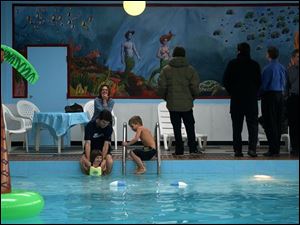 CTY mural25p Seagate Hotel guest Sarah Kennedy watches her husband, Derek Vaillant with their children, Janet, 3, and Ty, 5, play in the pool while a reception is being held for the TSA mural, Friday, Feb. 25, 2005. The Blade/Lori King
