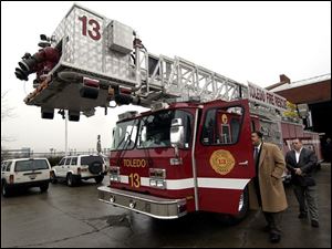 CTY firetruck28p A -- Toledo Mayor Jack Ford, left, and City Councilman Bob McClosky look at a new aerial ladder truck at the fire station at Consaul and Front streets in East Toledo during a press conference Monday, 02/28/05. The Blade/Andy Morrison