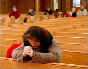 Frances McKenzie, who donned a traditional head covering before entering the sanctuary, prays during a weekday Mass at St. Joseph s on Locust Street.
