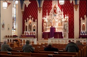 Father Stephen Majoros celebrates Mass at the newly renovated St. Joseph Church downtown. Though many pews are empty at weekday services, the weekend Masses, some of them in Latin, are attended by hundreds of parishioners. the blade/don simmons Frances McKenzie, who donned a traditional head covering before entering the sanctuary, prays during a weekday Mass at St. Joseph's on Locust Street.