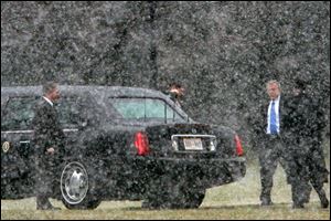 President Bush is caught in a snow flurry as he walks to his limousine from the Oval Office on his way to deliver a foreign policy address at the National Defense University.