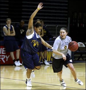Rocket assistant and Minnesota Lynx pro Amber Jacobs tests the defensive ability of Toledo's Olivia Terry. Terry was named to the All-MAC freshman team. Jacobs was an All-American at Boston College.
