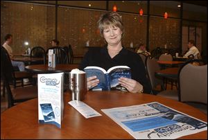 Mary Rothey, program officer at the Findlay-Hancock County Community Foundation, reads Rocket Boys by Homer Hickham at Coffee Amici in downtown Findlay.