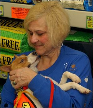 Pet psychic Anni Germani talks to one of the dogs at an
adopt-a-thon at Pet Supplies Plus on West Central Avenue.
