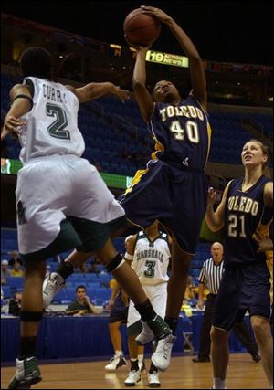Marshall's Kashawna Curry, left, tries to block a shot by Toledo's Amanda Davis in the MAC tourney in Cleveland.