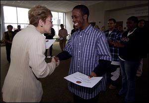 Marcy Kaptur shakes hands with Marcus Carvey, a Scott High School senior, after presenting him a certificate for his participation in the youth ambassador program.