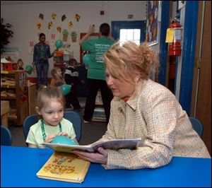 Brandi Chasteen, 6, listens to Ronda Hice, owner of Casey's Castle, read to her at the day-care center on West Alexis Road.