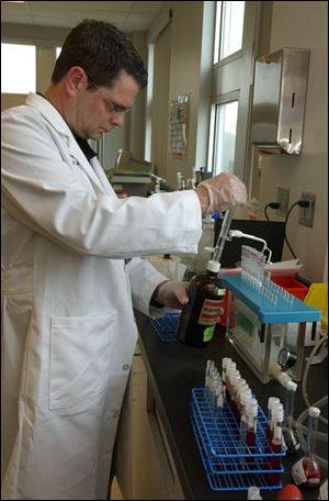 Tim Aukerman, toxicologist supervisor for the Lucas County coroner's office, works on extractions of samples from coroner's cases in the spacious new forensic toxicology lab on Arlington Avenue in South Toledo that is now almost fully operational.
