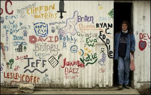 Holly Clouse, alternative-school founder, takes a last walk in a barn where students signed names after graduation.