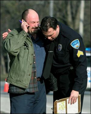 Oregon police Sgt. Ken Reno comforts Wayne Appenfelder, whose great-nephew Dameatrius
McCreary, 5, was struck and killed by a car as he exited a school bus on Starr Avenue.
