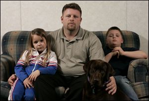 Andrew Purtee, with his children, Sydney, 5, and Andrew, 9, and their dog Brooke, blames a neighbor for the shooting death of two other pets.
