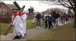 CTY crosswalk25 1 St. Joseph Catholic Church deacons Bob Pluciniak, front, and Ed Ireland lead the Way of the Cross procession in front of St. Paul's Lutheran Church in Maumee, OH., Friday, March 25, 2005. The Blade/Lori King