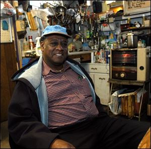 Retired teacher Winfred Falls works in his outboard engine repair shop on Wamba Avenue.
