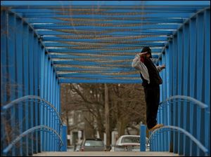 ROV trainspotting21p .jpg  Gregory Carter of south Toledo stands on the pedestrian overpass  over the railroad off of Emerald Avenue at Anthony Wayne Trail looking for trains 03/21/2005. The Blade/Lisa Dutton