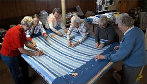 Judy Nieman, Sylvia Pecsenye, Ruth Olrich, Irene Koester, Pat Ortman, and Anna Rittner, from left use their
talented fi ngers to produce quilts in the basement of Zion Lutheran Church.
