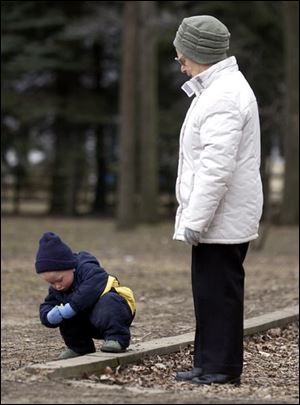 ROV Olander A -- Alex Milochnitchenko, 2,  finds something interesting to look at as his grandmother Elena Milochnitchenko waits patiently. The pair were spending time at Olander Park Monday, 03/21/05. The Blade/Andy Morrison
