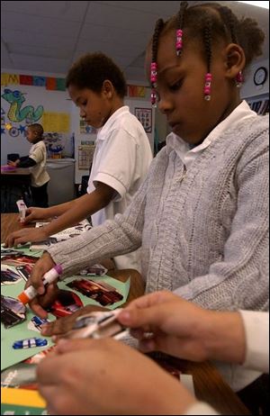 Mercedes Clayborne and Harry Guest, first-grade students at Winterfield Venture Academy, work on an art project during their lesson on transportation.