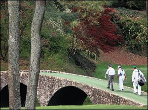 Jack Nicklaus, left, and Gary Player, center, walk across the 
Hogan Bridge on the way to the 12th hole at Augusta National.