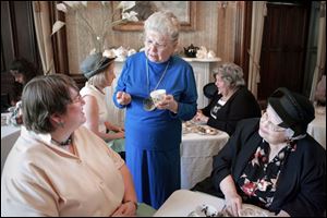 Ellen Kraus, center, explains a tea leaf reading to Deborah Humberger, left, and her mother Barbara during the Victorian Tea at the Dillon House in Fremont. Ms. Kraus owns a tea room in Sandusky and also performs astrological readings. 