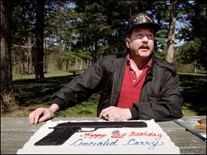 Bruce Beatty observes the 1st anniversary of legislation allowing concealed-carry in Ohio with a birthday cake in Ottawa Park at his pistol-packing picnic.