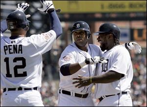 Marcus Thames, center, is greeted by Carlos Pena, left, and Dmitri Young, right, after his grand slam in the third inning.