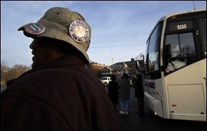 Jacquelyn Mullins of Toledo waits to board one of three buses that carried demonstrators to Columbus to protest planned cuts in human services in Ohio's two-year, $51.3 billion budget.