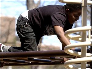 CTY  rove  Ottawa Park.  Jamie Lamont Hicks has fun bars  at the playground.   Jamie  rode his bike over with neighbors since it was such a pretty day.    The Blade/Diane Hires  4/13/05