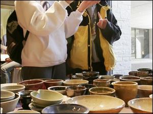 ROV  Catie (cq) Antoline, 22, left, and Amanda Cochran, 22, right, decide which bowls to buy during a "Throwing for Tsunami" fundraiser sponsored by the Toledo Campus Ministry Fellowship, at the University of Toledo, on Wednesday, 4/13/05.   The organization got the ceramics department at the university to make and donate ceramic rice bowls, which the campus ministry organization was selling for $5 and $10 in the Student Union.  The proceeds were being given to an organization called Church World Service, a cooperative ministry of 36 Protestant, Orthodox, and Anglican denominations, providing sustainable self-help and development disaster relief, and refugee assistance in more than 80 countries.  The  money from the UT event is going specifically to Tsunami survivors, according to Louise Chell, the 2005-2006 president of the Toledo Campus Ministry Fellowship.   The Blade/Dave Zapotosky