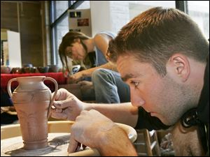 ROV   Raymond Nagley, 22, front, and Shannon Bauerschmidt, 22, back, both studio arts majors at the University of Toledo, demonstrate the art of ceramic making during a "Throwing for Tsunami" fundraiser sponsored by the Toledo Campus Ministry Fellowship, at the University of Toledo, on Wednesday, 4/13/05.   The organization got the ceramics department at the university to make and donate ceramic rice bowls, which the campus ministry organization was selling for $5 and $10 in the Student Union.  The proceeds were being given to an organization called Church World Service, a cooperative ministry of 36 Protestant, Orthodox, and Anglican denominations, providing sustainable self-help and development disaster relief, and refugee assistance in more than 80 countries.  The  money from the UT event is going specifically to Tsunami survivors, according to Louise Chell, the 2005-2006 president of the Toledo Campus Ministry Fellowship.   The demonstration took place during the sale. The Blade/Dave Zapotosky