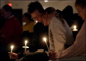 CTY vigil13p    Lisa Binkowski, left, puts her arm around her sister Danita Binkowski, right, during the candlelight vigil for victums of rape, domestic abuse, vehicular homicide or murder Wednesday evening 4/13/05 at St. Clement's Church.  The Blade/MAdalyn Ruggiero