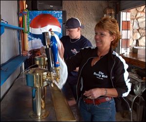 Bartenders Jamye Whaley and Tina Brewer shine up the beer taps in preparation for opening day at Fifth Third Field.
