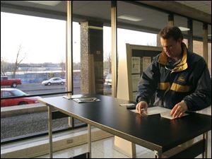 CTY taxday15p  While cars line up outside of the United States Postal Station on Superior Street in downtown Toledo, Ohio, Brad Burns, of Sylvania, inside the post office, puts the finishing touches on his tax returns on the evening of April 15, 2005. The Blade/Jetta Fraser