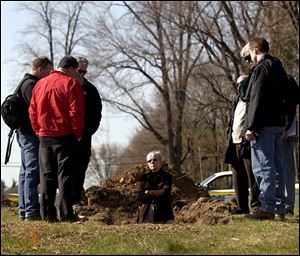 Forensic anthropologist Julie Saul, center, and other specialists survey the site where the bones were found.