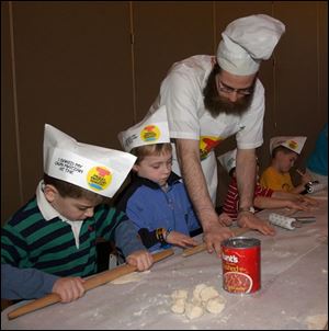 REL matzho10 2 from left, all five-year-old unless noted; Alex Goldstein, Adam Rusgo, Rabbi Shmuly Rothman of Chabad House-Lubavitch, Trevor Kruszynski, 4, and A.J. Federman, make matzah during class at The Temple in Sylvania, Sunday, April 10, 2005. The Blade/Lori King