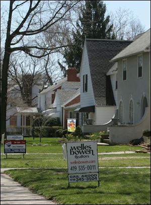 Adjacent houses await buyers on a block of Elmhurst Road in west Toledo.