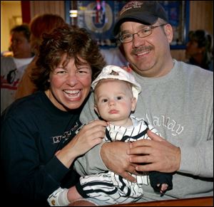 FUTURE MUD HEN: Garrison Cichocki, center, with parents Mary Watkins and Dave Cichocki, is ready to play ball.