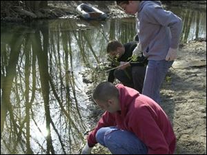 nbr earth16p 5   front to back Chris Jones, Jessica McGeorge, and Bryan Kromenacker plant trees by the river for  during earth day cleanup at wildwood preserve.  saturday 04/16/05  luke black/the blade