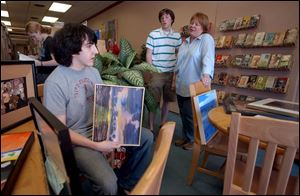 Bowling Green High School students Matt Mauk, left, and John Winkle chat with their teacher, Kim Sockman, about the art that will hang in the Grounds for Thought coffee shop.